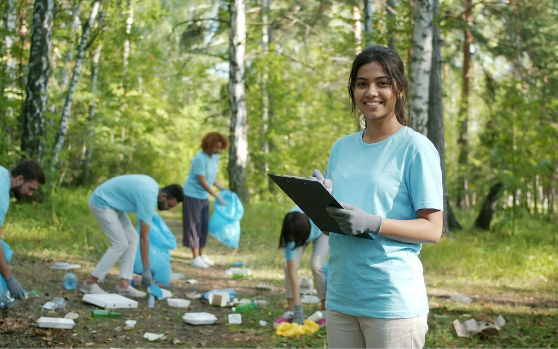 A field worker with a clipboard, a clean-up crew working behind her