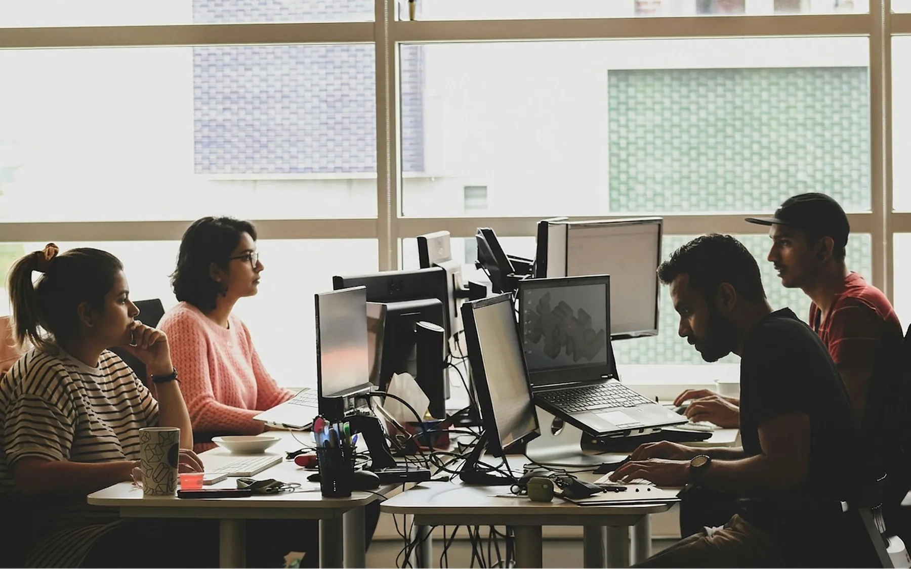 A team at their monitors in an open office