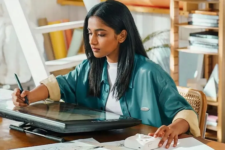 A woman drawing on a graphics tablet at her desk