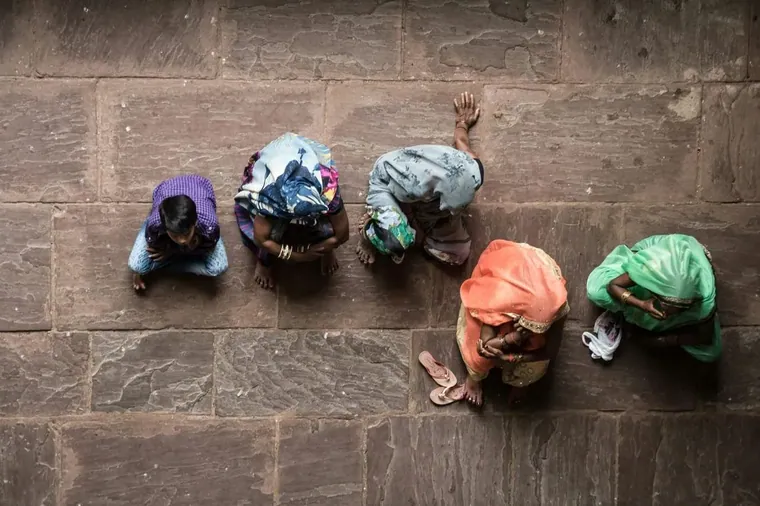 Four people crouched on the ground at work, from above