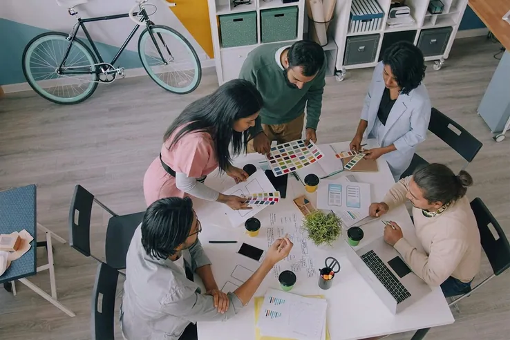 A team around a table of material swatches
