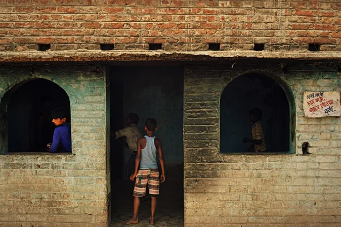 Children in the arched doorways of a brick building