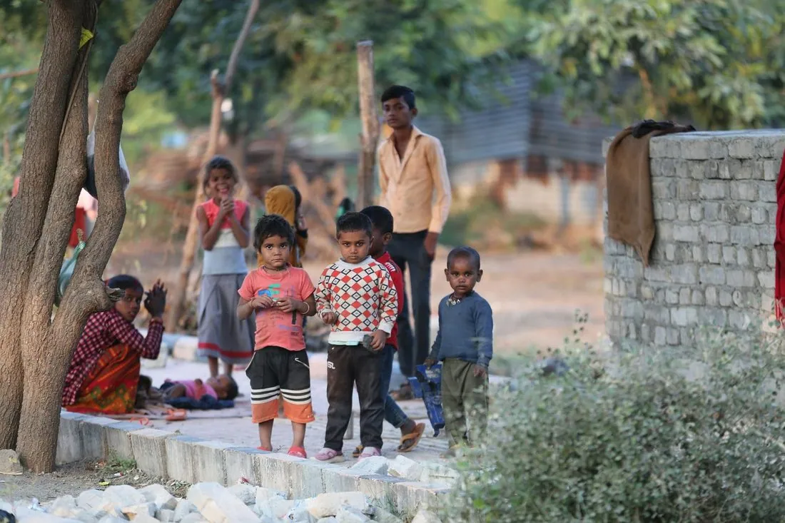 Children and adults outside a half-built house