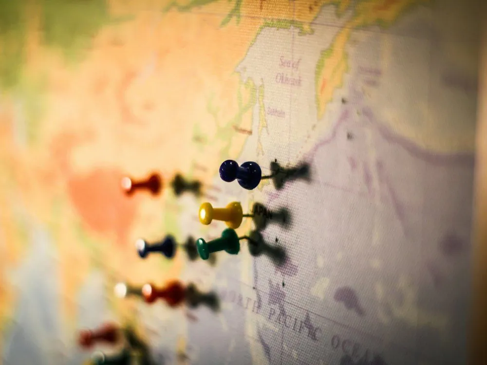 Pins marking places on a wall map