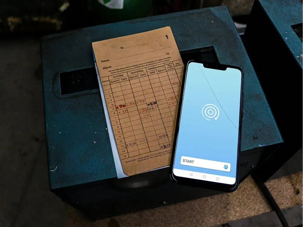 A phone and a paper form side by side on a desk
