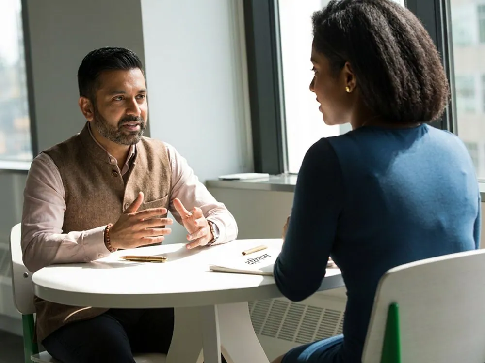 A man and a woman talking across a table