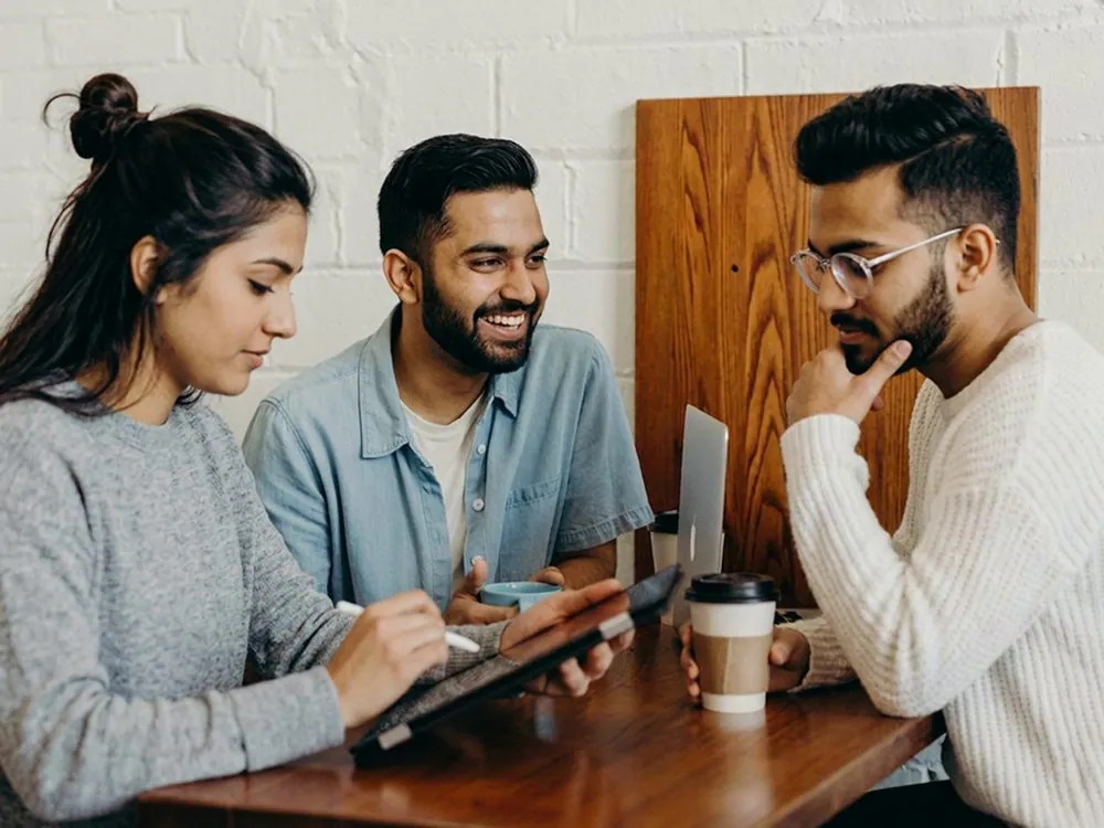 Three colleagues at a laptop together