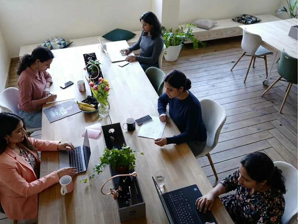 A team meeting around a long table, from above
