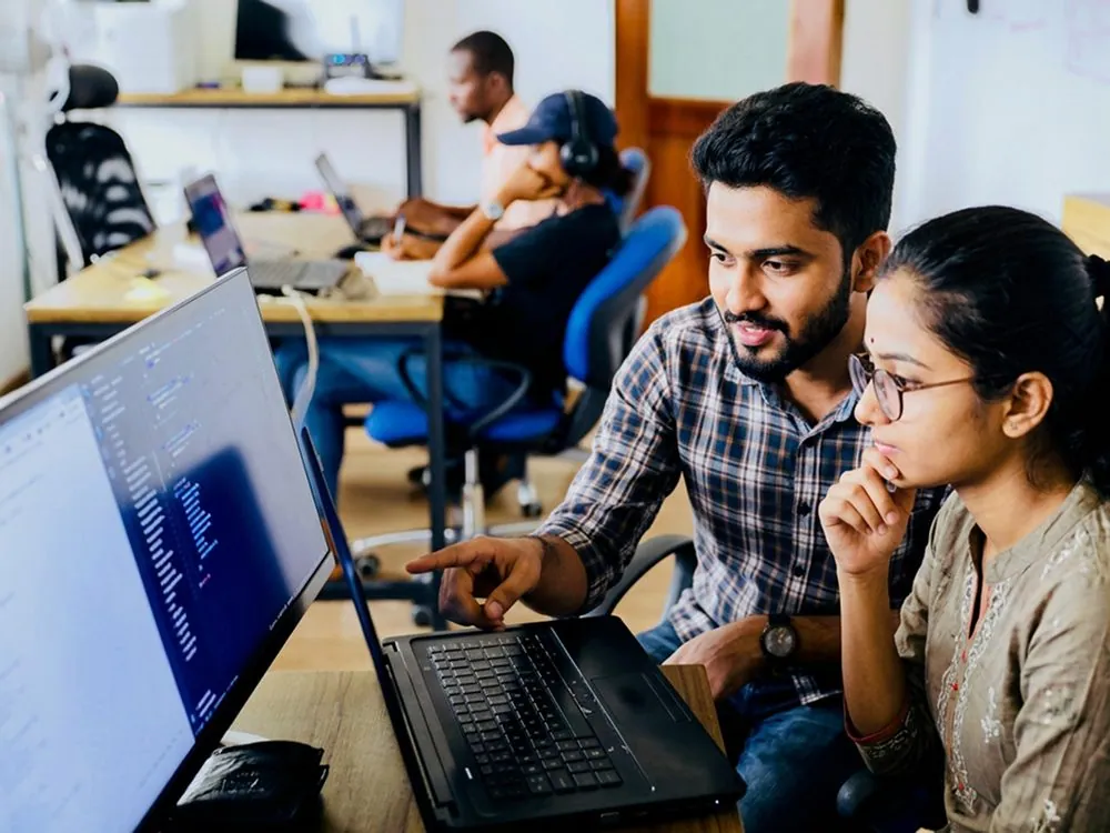 Two people working at a computer in a training lab