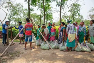 Villagers collecting waste into sacks