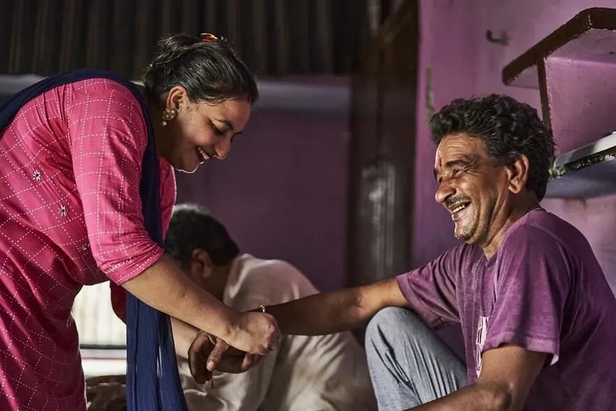 A health worker examining a man at a camp