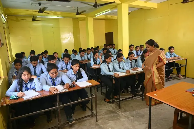 Girls in uniform at their desks with their teacher