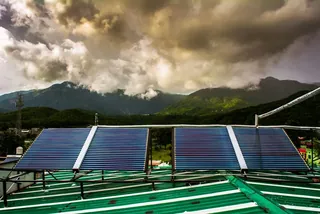 Solar panels on a roof with hills behind