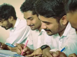 Young men in uniform writing at their desks