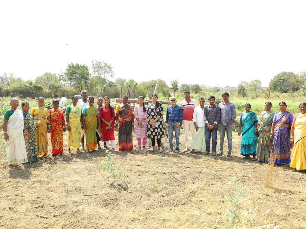 A large group of farmers along the edge of a field