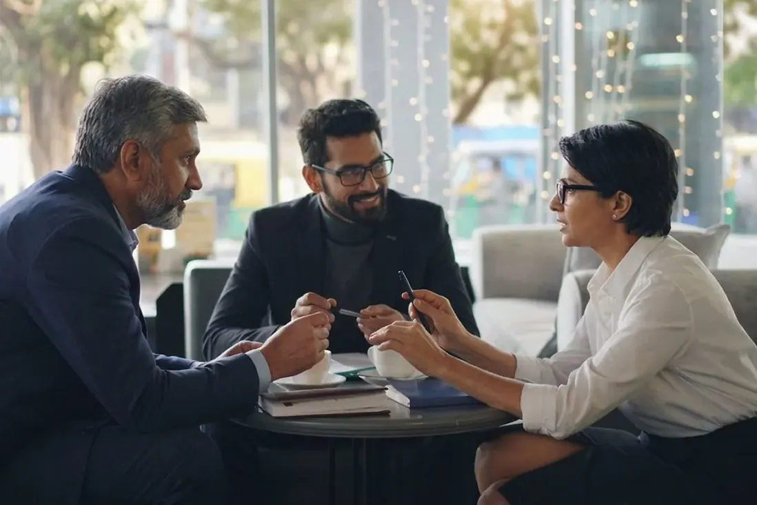 Three people in discussion across a table