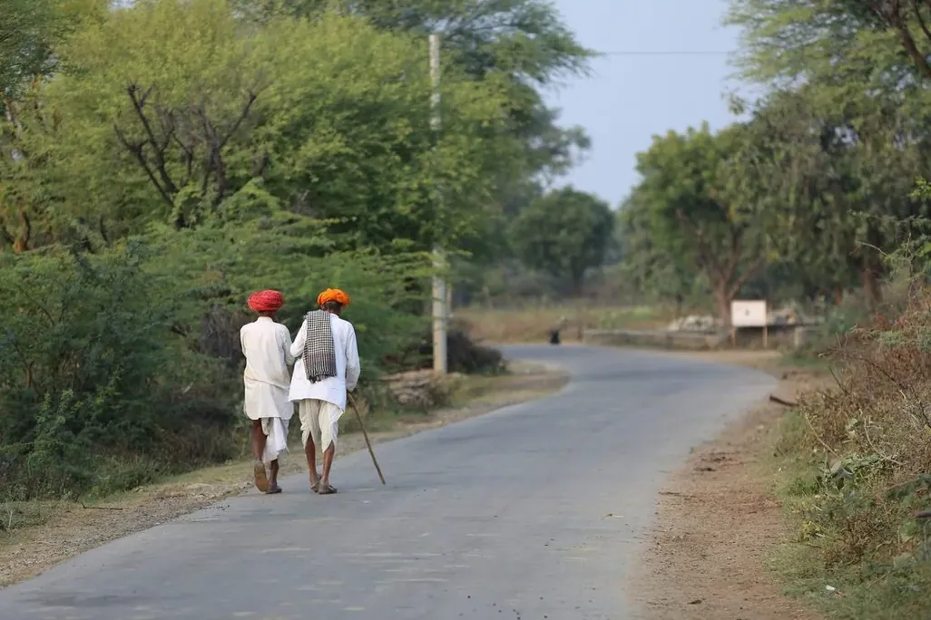 Two men walking a village road