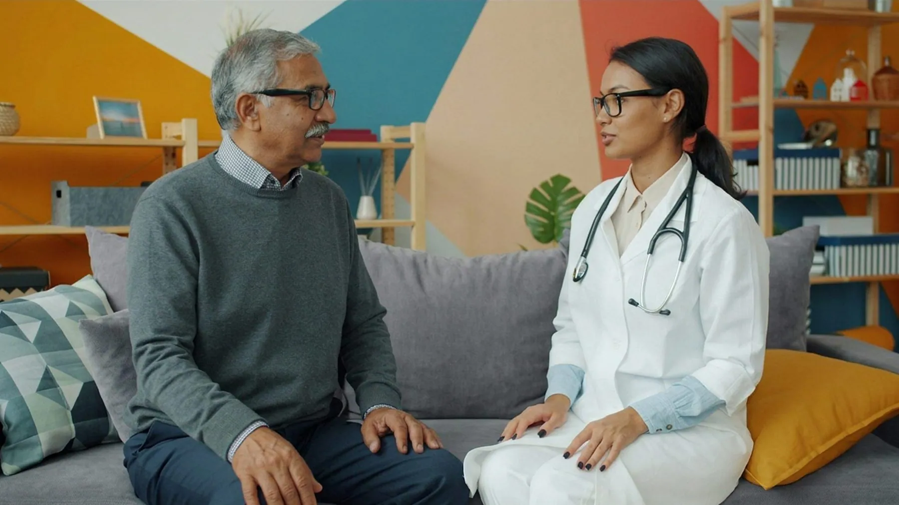 A doctor on a home visit, talking with an older man