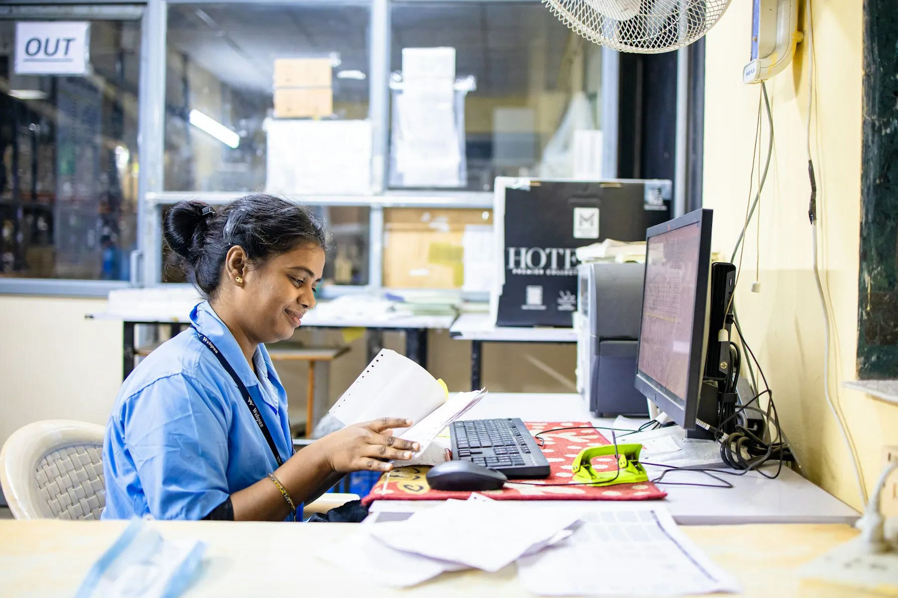 A health worker at her desk among files and a computer