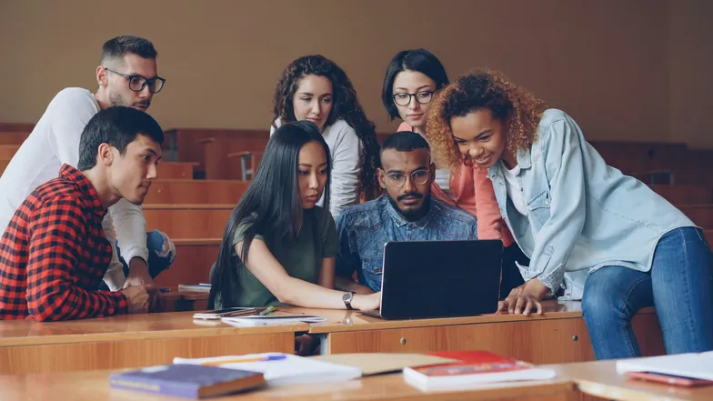 A team gathered around a laptop