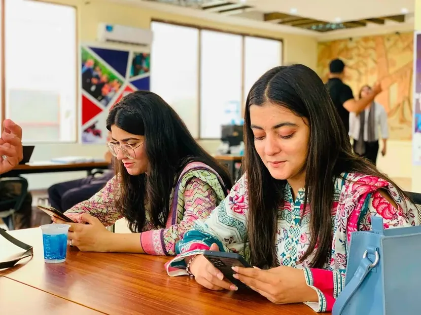 Two young women working at a table in a classroom