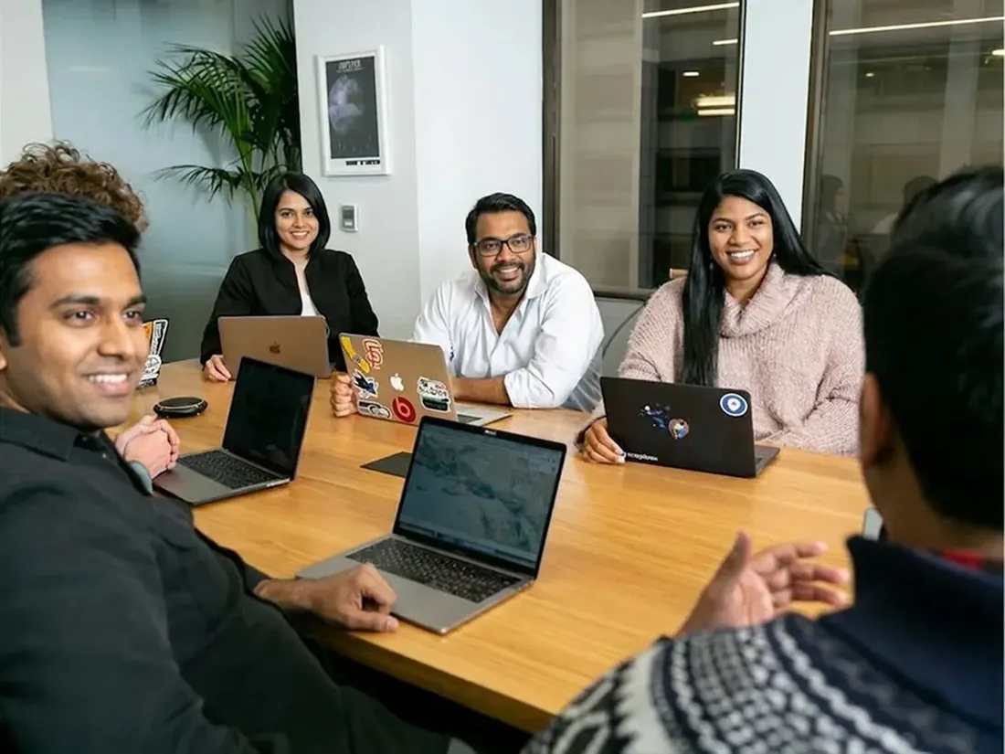 A team with laptops around a table