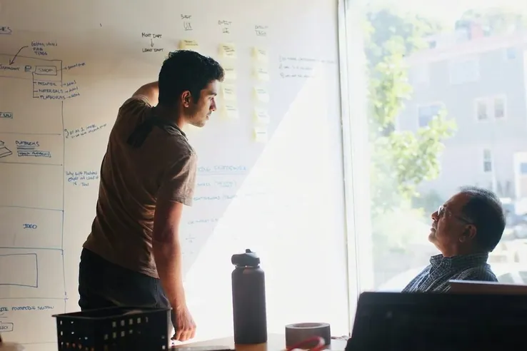A woman working at a glass wall of diagrams