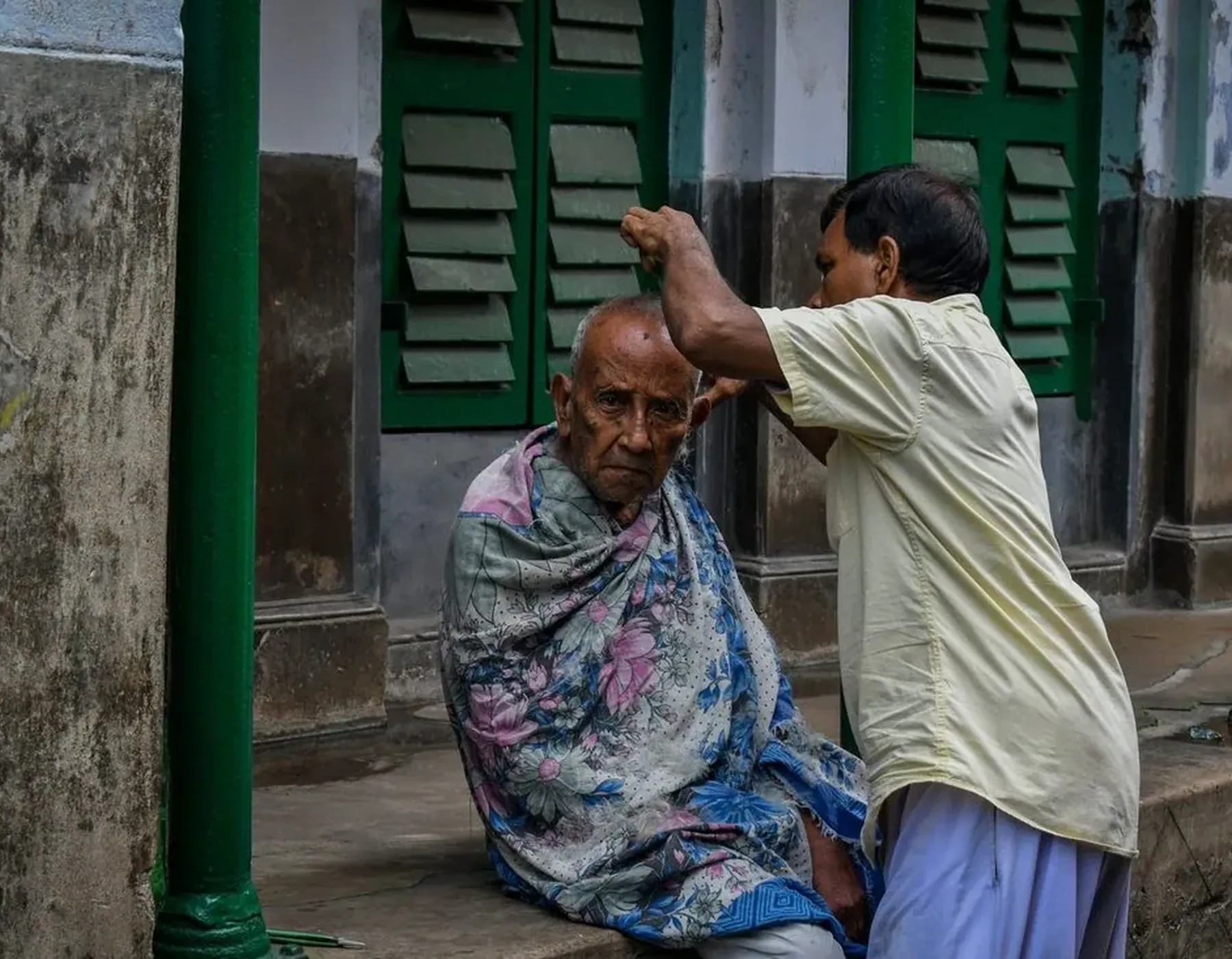 An older woman at her doorway, a man at the window