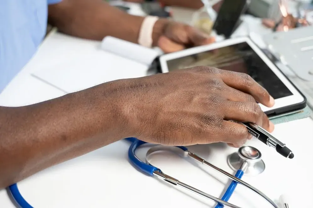 Hands with a tablet and a stethoscope